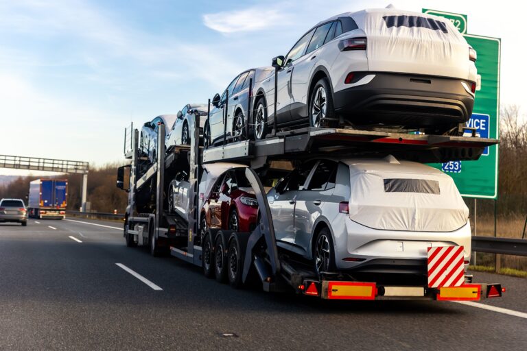 A car carrier truck transporting covered vehicles on a highway