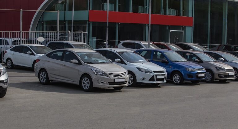 Rows of cars are parked outside an auction house