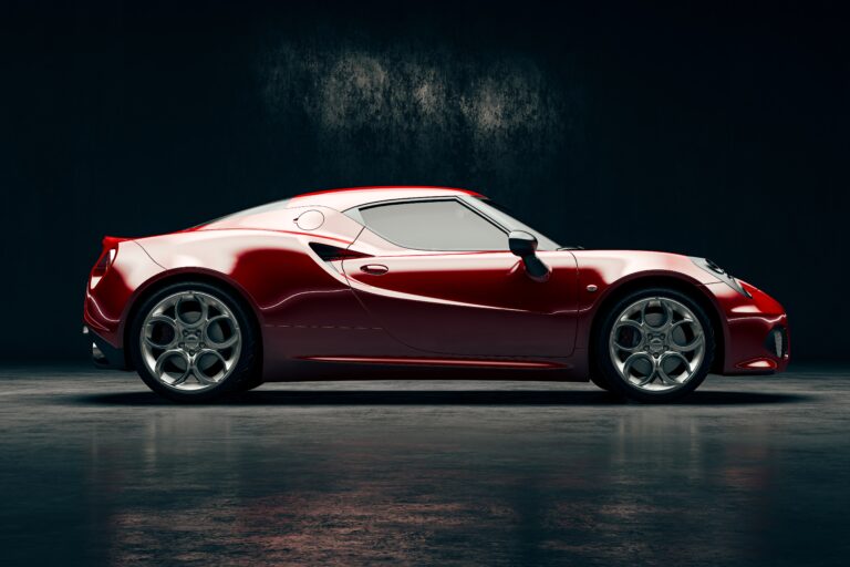 A sleek red exotic car parked in a dimly lit studio, showcasing its aerodynamic design and polished finish.