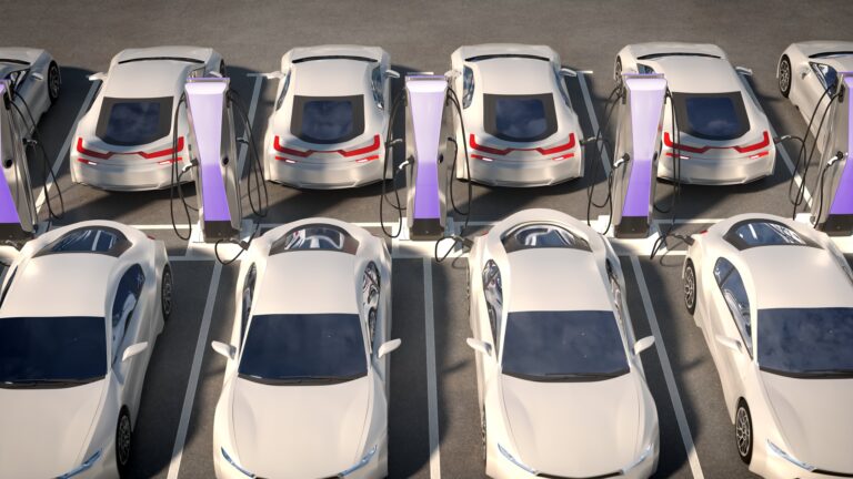 Electric cars charging at stations in a parking lot, symbolizing the future of automotive technology