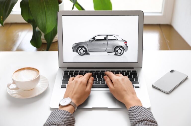 A person using a laptop to sell cars on an online platform