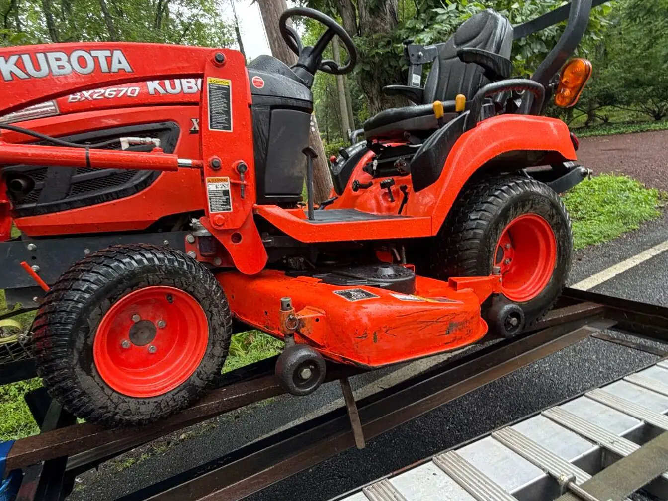 Small Kubota Tractor on an open trailer